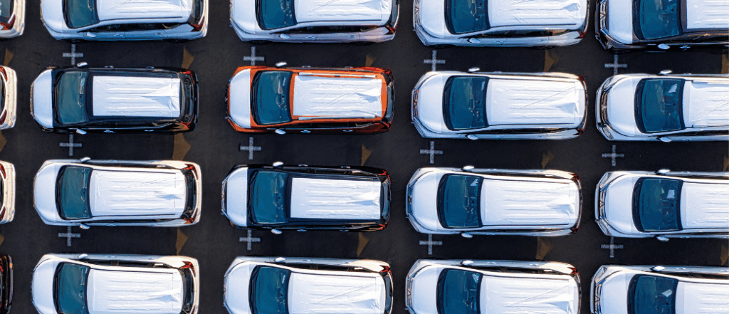 Aerial view of a fleet of parked vehicles in a car park, representing fleet management and tracking.